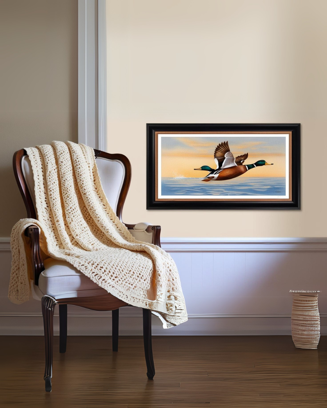 Traditional upholstered armchair draped with a cream knit throw, styled beneath a framed painting of ducks in flight in a calm, neutral interior.